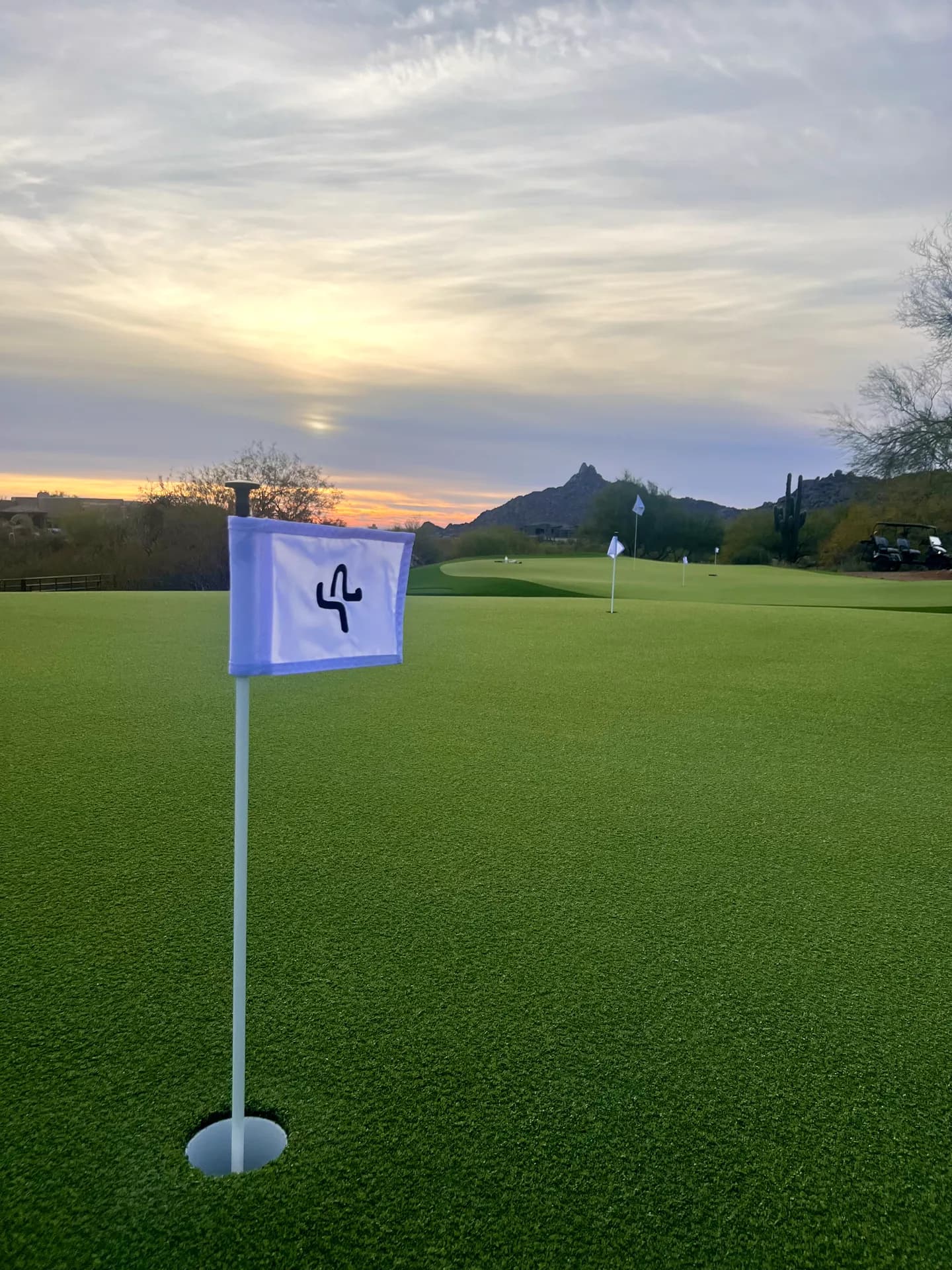 The logo flag at dusk beneath a Sonoran sunset