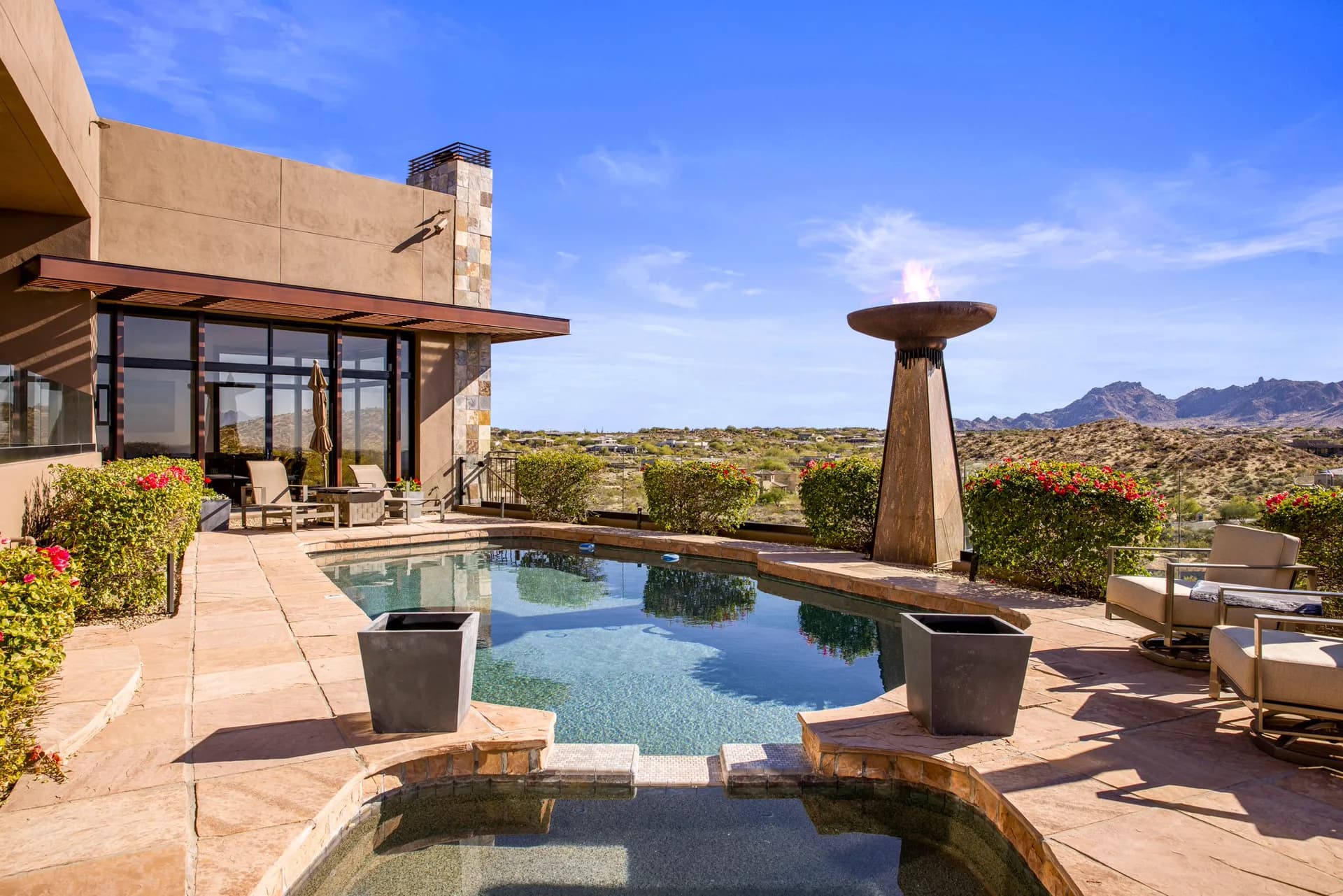 Saguaro Point's heated pool, spa, and torch fountain with mountain views on a summer day