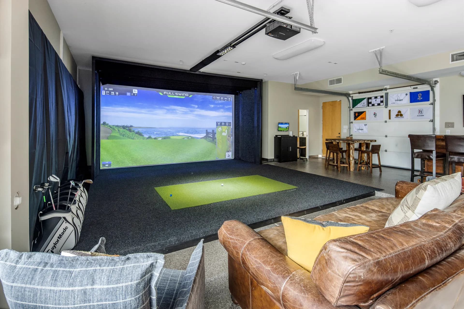The Full Swing simulator mid-round with hitting mat and lounge