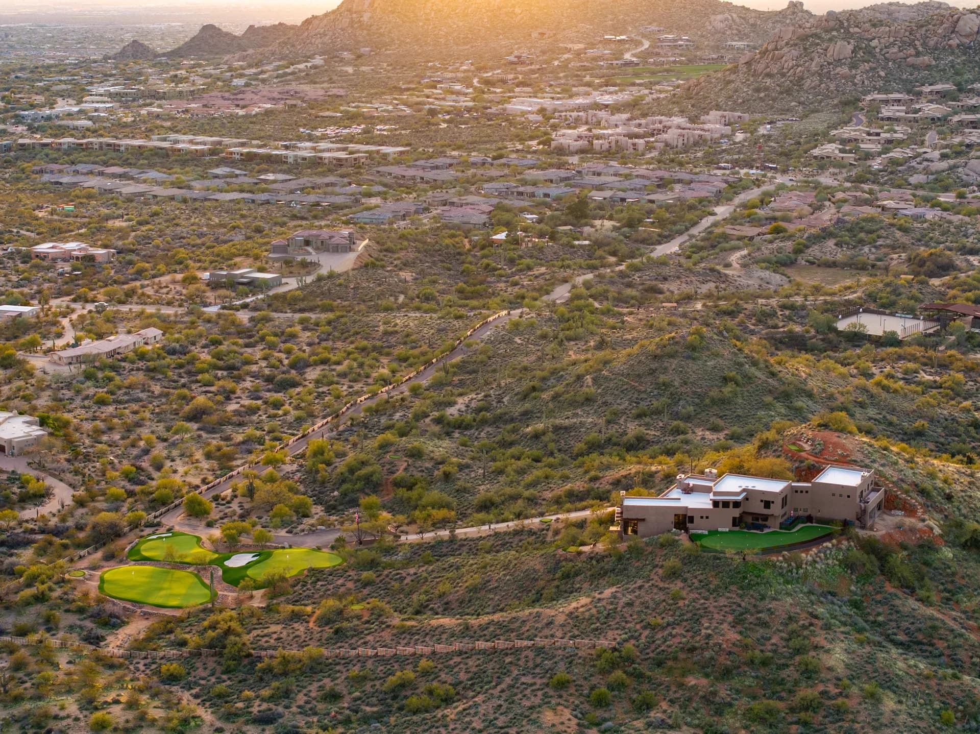 Aerial view of the golf complex and estate above the valley at sunset