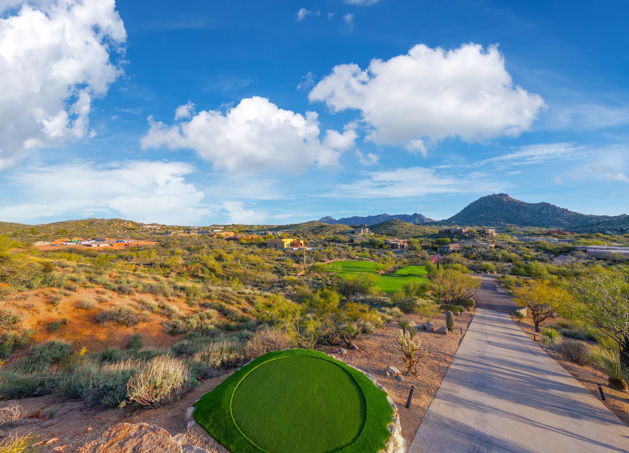 The circular chipping green beside the estate driveway, desert mountains in the distance