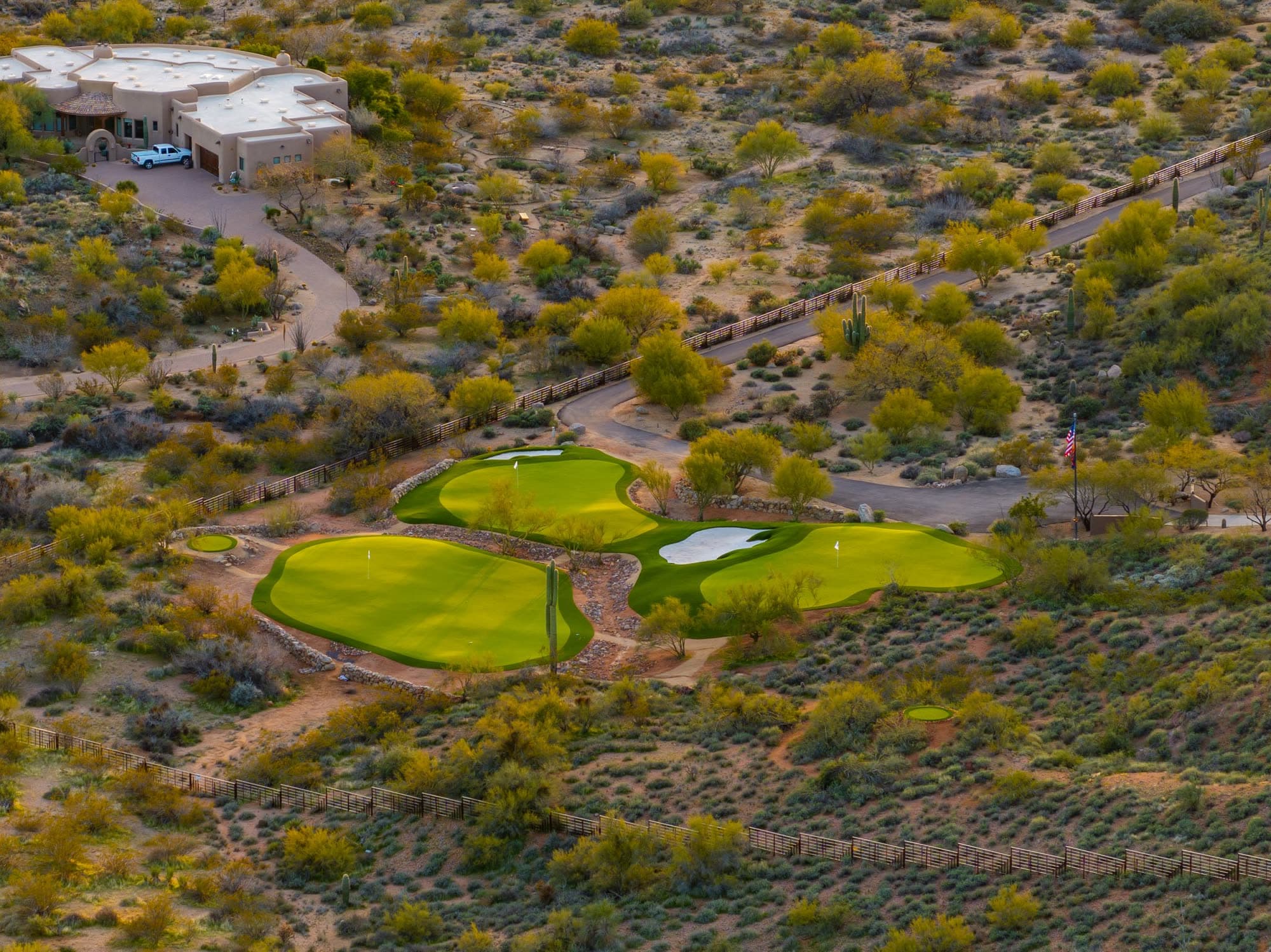 The three-green practice complex at Saguaro Point in golden-hour light