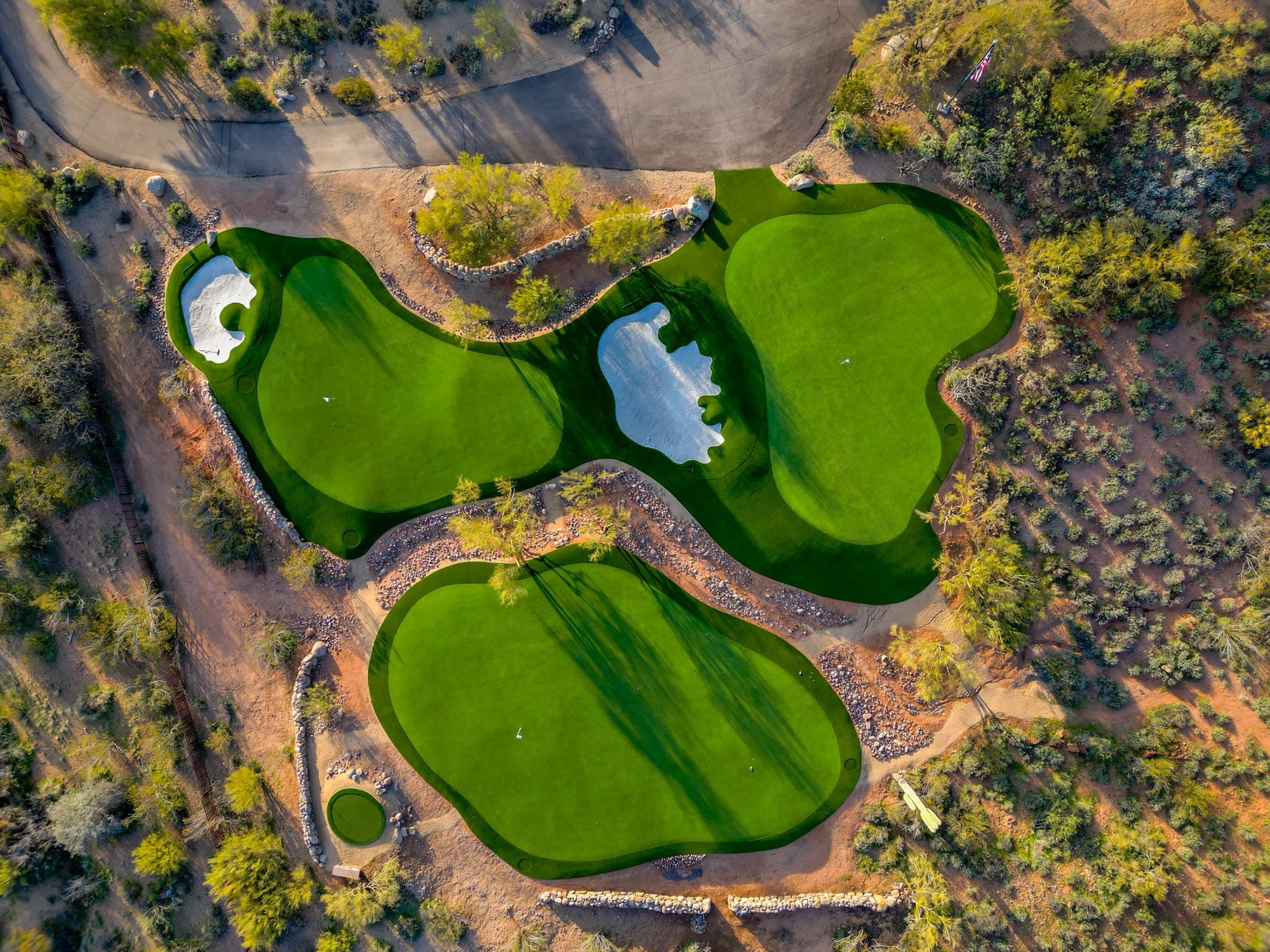 Overhead of the Saguaro Point greens pulled back to show the cart path, flagpole, and circular green