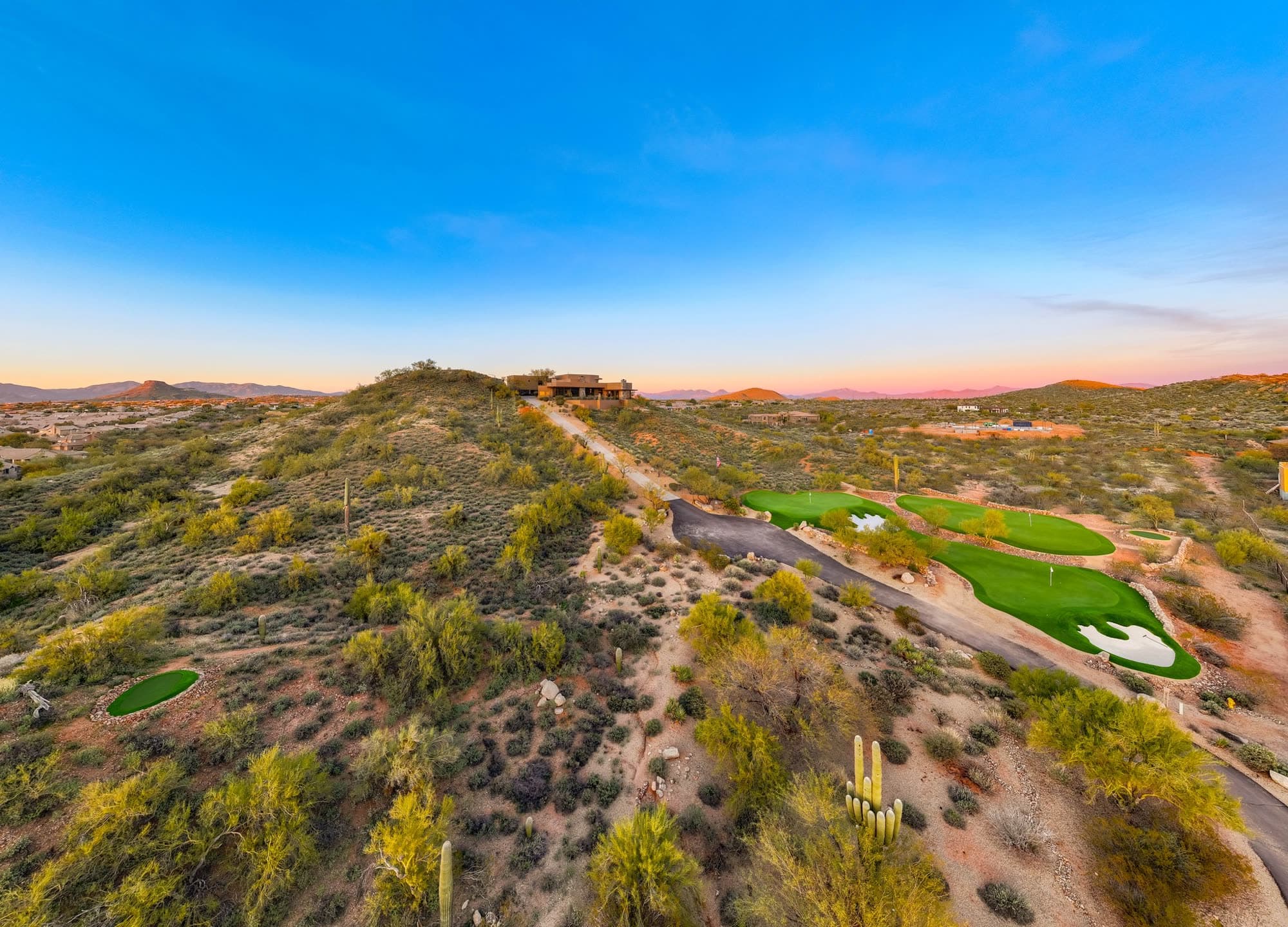 The ridge and greens beneath a wide open Sonoran sky at dusk