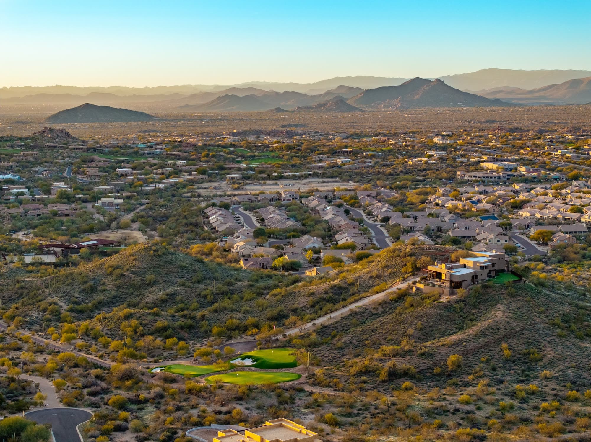 Golden hour across the North Scottsdale valley toward Troon, with the estate at lower right